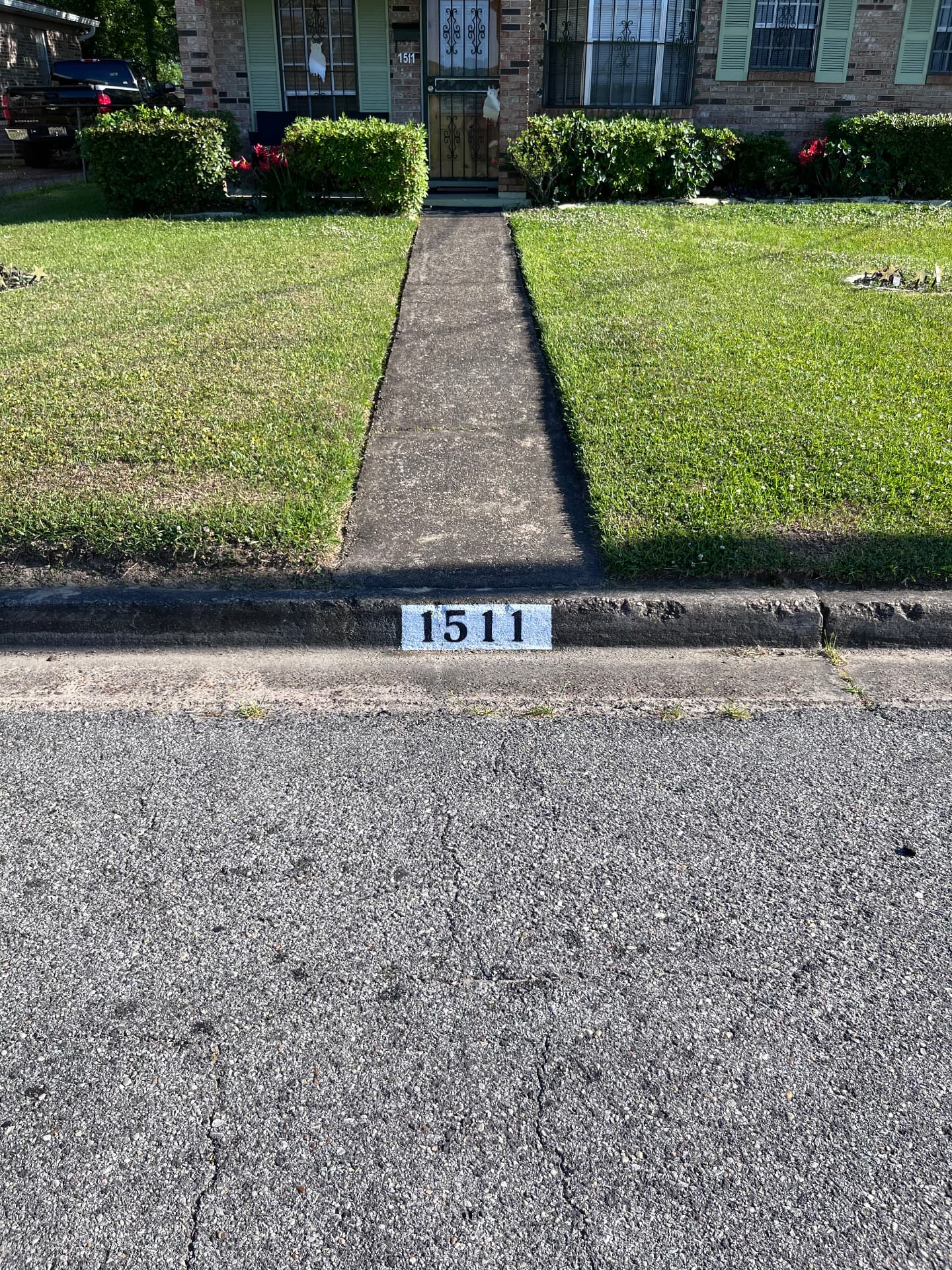 Professional curbside address numbers painted on a residential concrete curb
